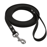 Biothane-Schleppleine mit Handschlaufe in Schwarz, aufgerollt, mit Chrom-Karabiner und zwei Nieten