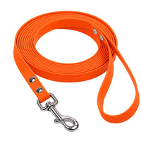 Biothane-Schleppleine mit Handschlaufe in Neonorange, aufgerollt, mit Edelstahl-Karabiner und zwei Nieten
