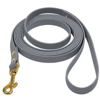 Biothane-Schleppleine mit Handschlaufe in Grau, aufgerollt, mit Messing-Karabiner und Messingnieten