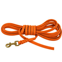 Fettleder-Schleppleine ohne Handschlaufe in Orange, eng aufgerollt, geflochtener Anschluss am Messingkarabiner