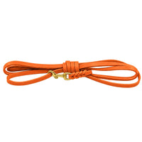Fettleder-Schleppleine ohne Handschlaufe in Orange, flach in Schlaufen gelegt, mit Messingkarabiner und Flechtung