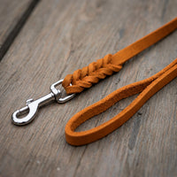 Detail: Fettlederleine in Cognac auf Holzdielen, geflochtenes Ende mit Edelstahlkarabiner und Handschlaufe