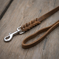Detail: Fettlederleine in Braun auf Holzdielen, geflochtenes Ende mit Edelstahlkarabiner und Handschlaufe