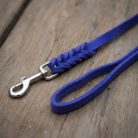 Detail: Fettlederleine in kräftigem Blau auf Holzdielen, geflochtenes Ende mit Edelstahlkarabiner und Handschlaufe