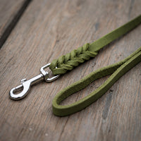 Detail: Fettlederleine in Oliv auf Holzdielen, geflochtenes Ende mit Edelstahlkarabiner und Handschlaufe