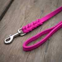 Detail: Fettlederleine in Pink auf Holzdielen, geflochtenes Ende mit Edelstahlkarabiner und Handschlaufe