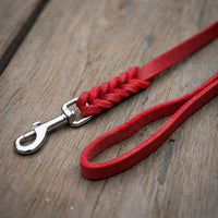 Detail: Fettlederleine in Rot auf Holzdielen, geflochtenes Ende mit Edelstahlkarabiner und Handschlaufe