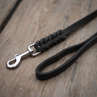 Detail: Fettlederleine in Schwarz auf Holzdielen, geflochtenes Ende mit Edelstahlkarabiner und Handschlaufe