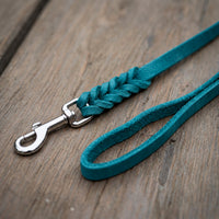 Detail: Fettlederleine in Türkis auf Holzdielen, geflochtenes Ende mit Edelstahlkarabiner und Handschlaufe