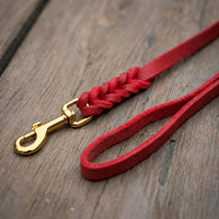 Detail: Fettlederleine in Rot auf Holzdielen, geflochtenes Ende mit Messingkarabiner und Handschlaufe