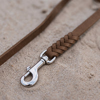 Detail: geflochtenes Ende mit Edelstahlkarabiner an Fettlederleine in Braun auf Sand