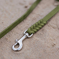 Detail: geflochtenes Ende mit Edelstahlkarabiner an Fettlederleine in Oliv auf Sand