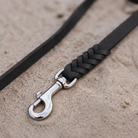 Detail: geflochtenes Ende mit Edelstahlkarabiner an Fettlederleine in Schwarz auf Sand