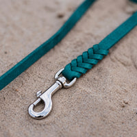 Detail: geflochtenes Ende mit Edelstahlkarabiner an Fettlederleine in Türkis auf Sand