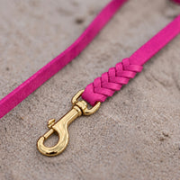 Detail: geflochtenes Ende mit Messingkarabiner an Fettlederleine in Pink auf Sand