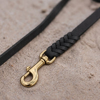 Detail: geflochtenes Ende mit Messingkarabiner an Fettlederleine in Schwarz auf Sand
