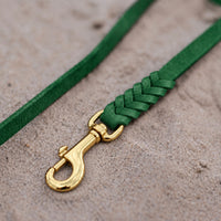 Detail: geflochtenes Ende mit Messingkarabiner an Fettlederleine in Tannengrün auf Sand