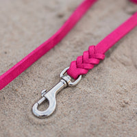 Detail: Edelstahl-Karabiner und Flechtverbindung einer Fettlederleine in Pink auf Sand
