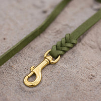 Detail: Messing-Karabiner und Flechtverbindung einer Fettlederleine in Oliv auf Sand