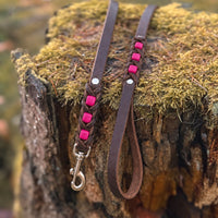 Führleine Melange aus dunkelbraunem Leder mit pinken Einsätzen auf moosbewachsenem Baumstumpf
